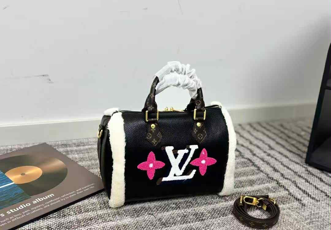 Designer handbag with floral design and brand logo on a textured surface